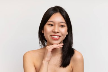 Pretty young korean lady with perfect skin in towel isolated on white background, studio shot. Beauty and health care, routine procedures for face, basic makeup, spa and cosmetics