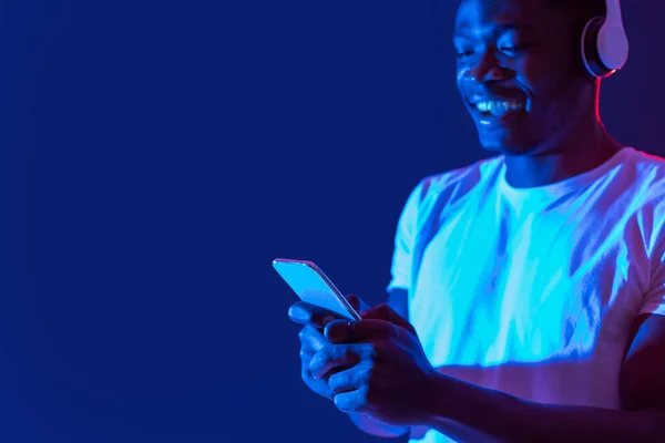 Young Black Guy Listening Music Wireless Headphones Using New Mobile — Stockfoto