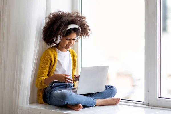 Closeup Cheerful Black Little Girl Wireless Headset Using Laptop Home — Stockfoto