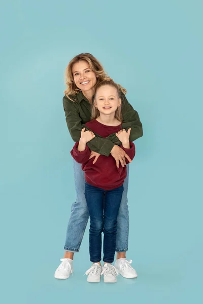 Vertical Shot Cheerful Mommy Hugging Her Kid Daughter Posing Standing — Stockfoto