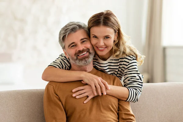 Happy Middle Aged Wife Hugging Husband Standing His Back Sitting — 图库照片