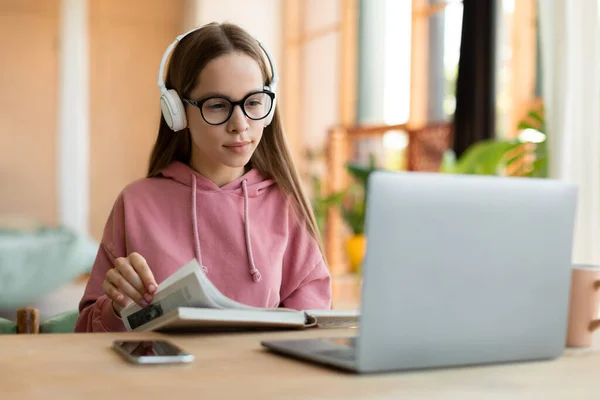 Focused Female Teenager Studying Reading Notebook Looking Laptop Screen Learning — Zdjęcie stockowe