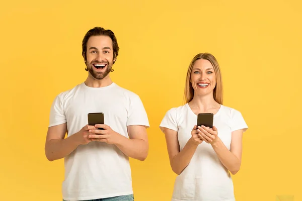Satisfied Millennial Caucasian Male Female White Shirts Typing Smartphones Isolated — Stockfoto