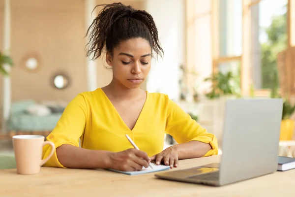 Focused Black Female Student Taking Notes While Watching Online Lecture — Stok fotoğraf