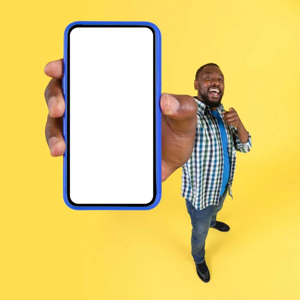 Cheerful Black Male Showing Huge Smartphone Pointing Finger Camera Advertising — Fotografia de Stock