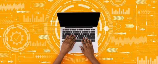 Young black man typing on laptop keyboard with blank screen on orange background with abstract symbols, collage, panorama. Networking, internet service, technology, modern tech, work and education