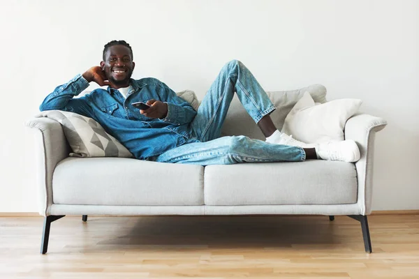 Happy Black Millennial Guy Watching Television Holding Remote Controller Relaxing — Foto de Stock