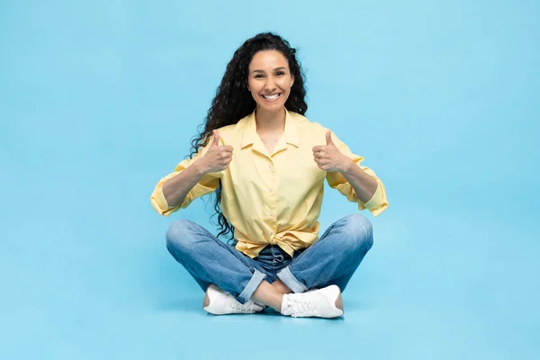 Happy Arabic Female Gesturing Thumbs Approving Offer Smiling Camera Sitting — Stockfoto