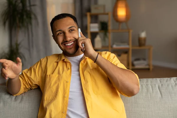Attractive Young Black Guy Having Smartphone Conversation While Sitting Couch — Foto de Stock