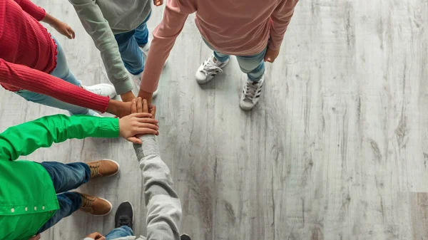 Teambuilding. Unrecognizable Kids Putting Hands Together Standing Indoors. Top View Shot Of Boys And Girls Stacking Arms. Teamwork And Unity Concept. Cropped, Panorama