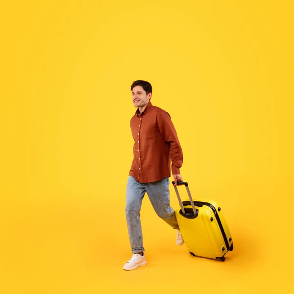 Happy Male Tourist Walking Luggage Going Vacation Yellow Studio Background — стоковое фото