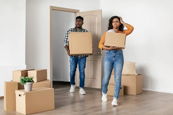 Disgusted Black Couple Entering New Bad House Carrying Moving Boxes — стоковое фото
