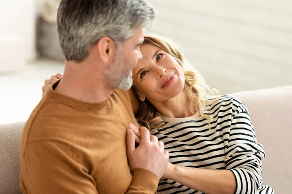 Cheerful Middle Aged Couple Embracing Sitting Couch Home Relaxing Together — 图库照片