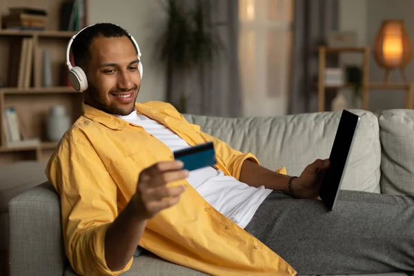 Positive Young Black Man Headphones Buying Goods Online Using Tablet — 스톡 사진