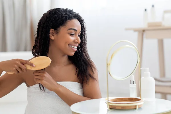 Beautiful African American Woman Combing Her Curly Hair Bamboo Brush — Zdjęcie stockowe