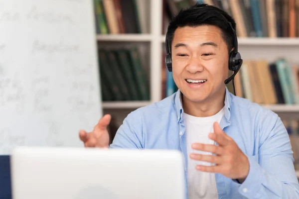 Cheerful Asian Middle Aged Man Video Calling Laptop Wearing Headset — Zdjęcie stockowe