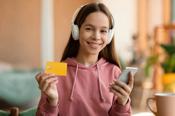 Щаслива Дівчина Підліток Тримає Кредитну Картку Платить Смартфоном Слухаючи Музику — стокове фото