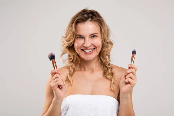 Closeup Portrait Beautiful Middle Aged Female Holding Two Makeup Brushes — Stockfoto