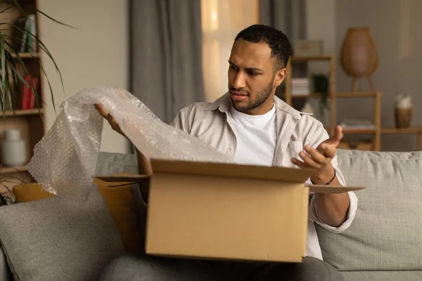 Dissatisfied Black Male Customer Opening Box Online Store Taking Out — Φωτογραφία Αρχείου