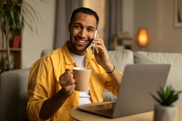 Happy Young African American Man Coffee Speaking Cellphone Using Laptop — Stockfoto