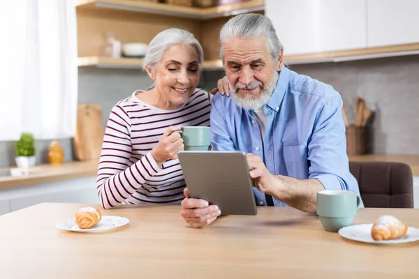 Happy Senior Spouses Using Digital Tablet Together While Having Breakfast — Stockfoto