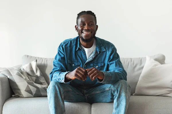 Happy Black Man Posing Smiling Camera Sitting Couch Home Millennial — Foto de Stock
