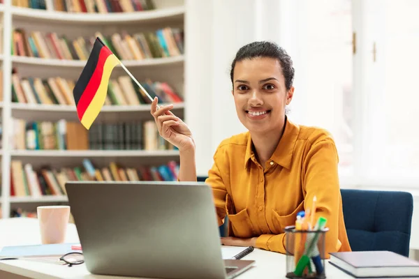 Happy Female Tutor Sitting Table Flag Germany Using Laptop Computer — Fotografia de Stock