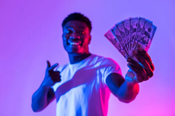 Happy Young Black Man Pointing Fan Money His Hand Neon — Zdjęcie stockowe