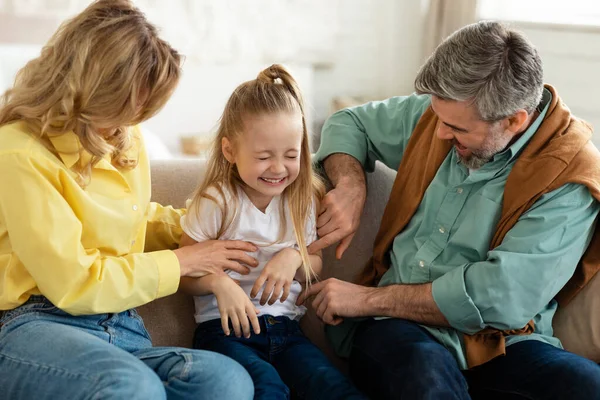 Loving Parents Tickling Little Daughter Having Playing Together Weekend Sitting — Stockfoto