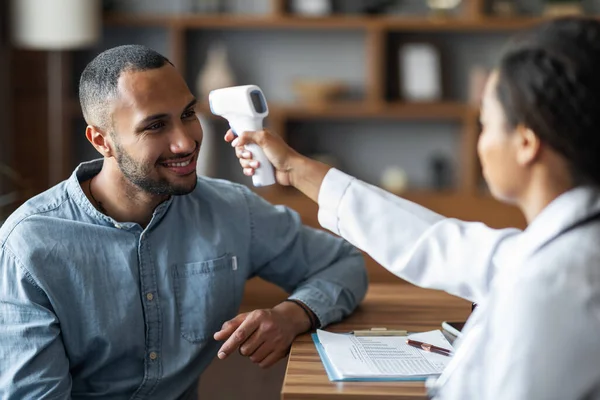 African American Millennial Woman Doctor Checking Patient Handsome Arab Guy — Stockfoto