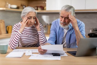 Stressed Senior Couple Checking Financial Papers And Planning Budget At Home, Upset Elderly Husband And Wife Looking At Loan Documents, Suffering Crisis While Calculating Family Spends, Closeup
