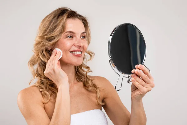 Beauty Routine Smiling Attractive Middle Aged Woman Holding Mirror Cleansing — Stockfoto