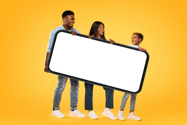 African American Family Three Holding Huge Smartphone White Empty Screen — Zdjęcie stockowe