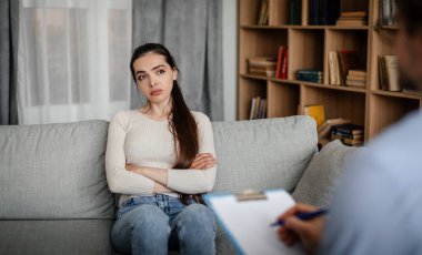 Melancholic sad european millennial woman patient look at male doctor, listen advice in clinic interior. Medical support, consultation with professional, disease treatment and support, health care