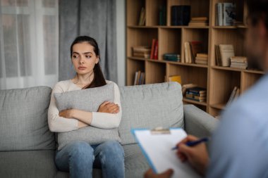 Unhappy sad young european woman listens to male doctor in office clinic interior. Prescription for depression treatment, mental help, medical support, psychological therapy, session with professional