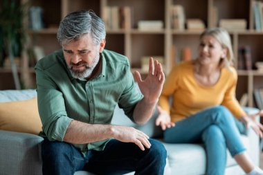 Relationship Problems. Portrait Of Middle Aged Spouses Arguing At Home, Angry Woman Emotionally Shouting At Husband, Mature Couple Suffering Marriage Crisis, Selective Focus On Upset Man