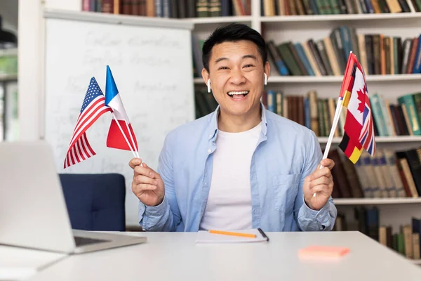 Happy Asian Language Teacher Man Holding Different Countries Flags Smiling — Fotografia de Stock