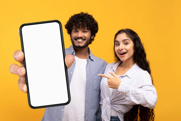Mobile Offer Cheerful Indian Couple Pointing Big Blank Smartphone White — стокове фото