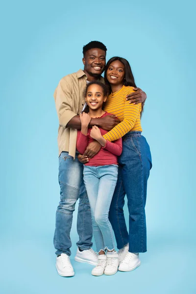 Loving Black Family Three Embracing Smiling Camera Posing Blue Background — Stockfoto