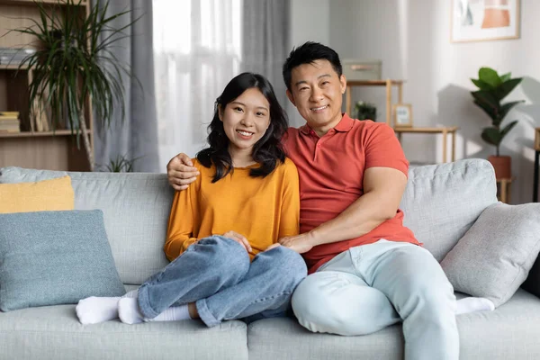Loving Chinese Couple Bonding Couch Home Cheerful Asian Man Hugging — Φωτογραφία Αρχείου