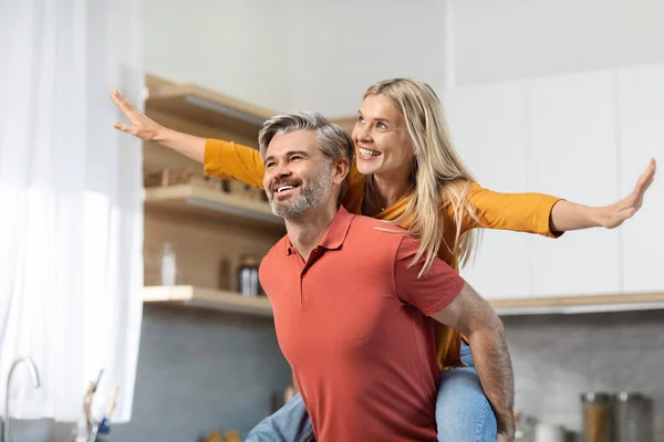 Happy Pretty Blonde Woman Piggybacking Her Cheerful Husband Looking Copy — Stock fotografie