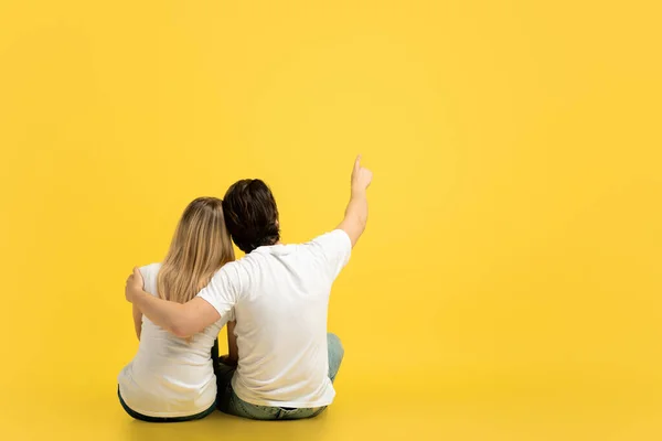 Happy Millennial Caucasian Man Hugging Woman Pointing Finger Empty Space — Stock Photo, Image