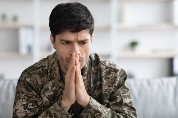 Thoughtful Military Man Staring Aside Holding Palms Mouth Sitting Couch — Foto de Stock