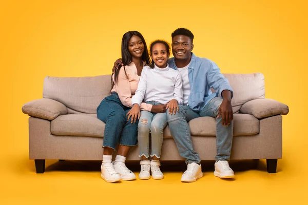 Happy Black Man Woman Girl Sitting Couch Embracing Yellow Studio — Fotografia de Stock