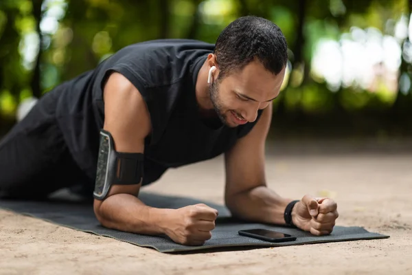 Motivated Young Black Guy Sportsman Planking Fitness Mat Public Park — Stockfoto