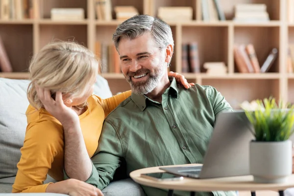 Loving Middle Aged Couple Bonding Together While Relaxing Laptop Home — Stock fotografie