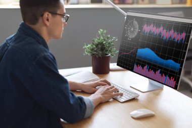Millennial Businessman Analyzing Statistics On Computer Screen In Office, Young Male Entrepreneur Working With Financial Graphs And Charts Online, Using Business Software For Data Analysis