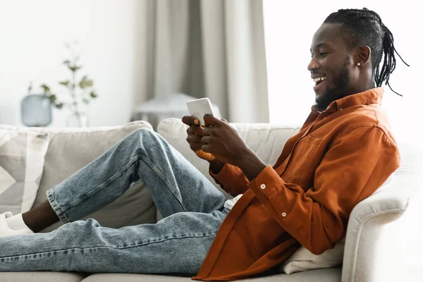 Joyful African American Man Reclining Couch Home Chatting Friends Playing —  Fotos de Stock
