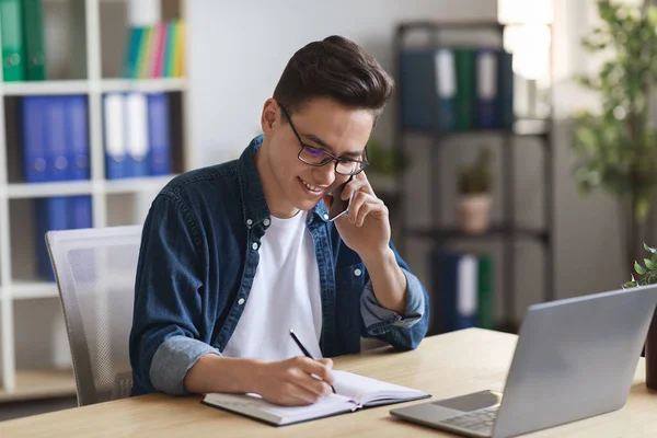 Young Office Manager Talking Mobile Phone Taking Notes Notepad Millennial — Foto de Stock