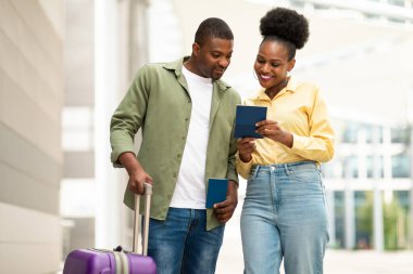 Seyahat et. Havalimanı Terminali 'nde durmakta olan neşeli Afro-Amerikan çift pasaport ve biletlerle poz veriyor. Turizm ve Tatil Teklifi Konsepti